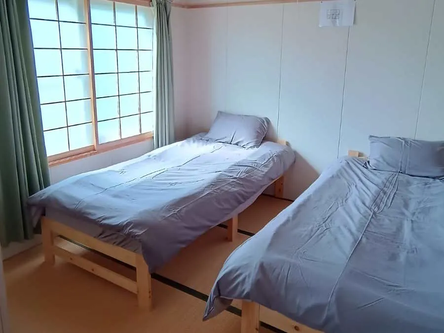 Second bedroom with wooden single beds and shoji screen