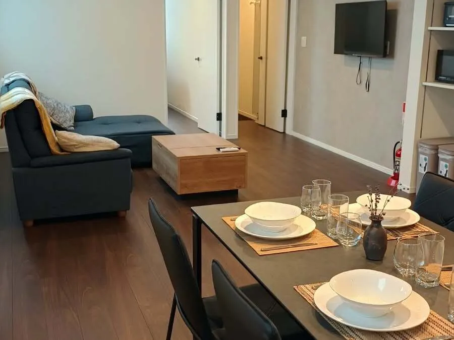 Dining table set for four with sofa behind