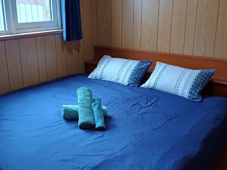 Double bed with blue duvet and folded towels