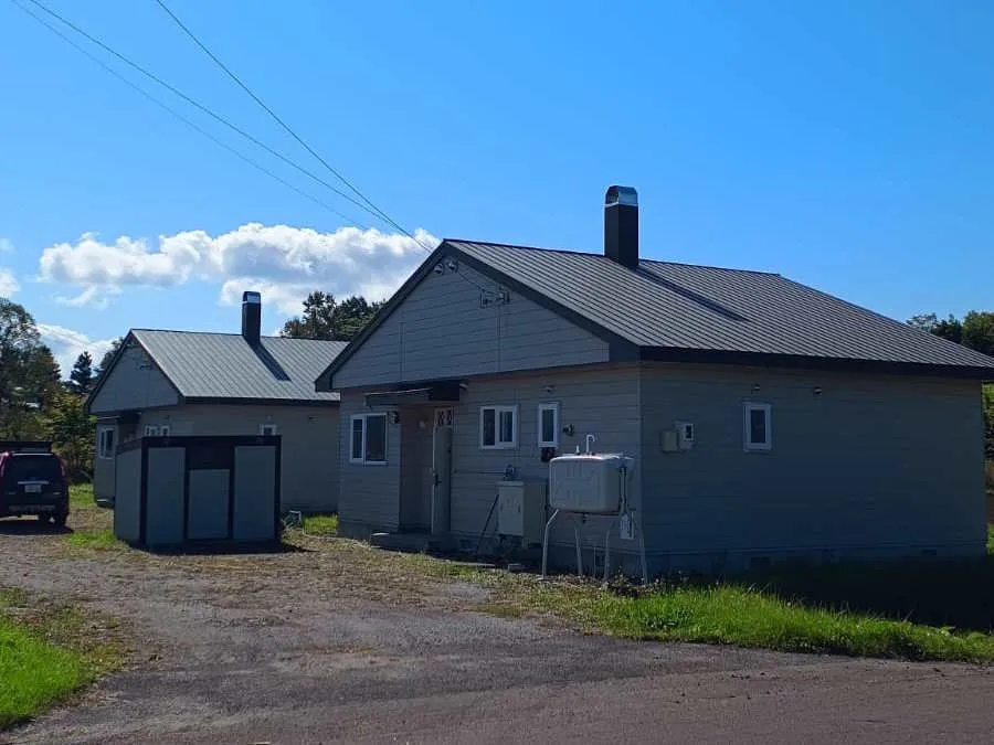 Summer driveway view with both cottages