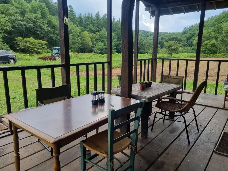 Porch deck with tables and chairs overlooking farm fields