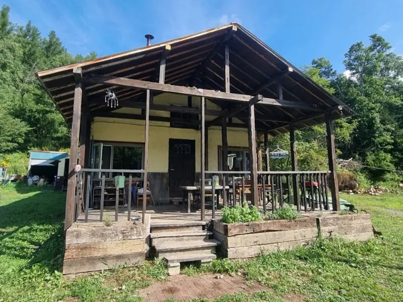 Bears House in summer with covered porch and blue sky