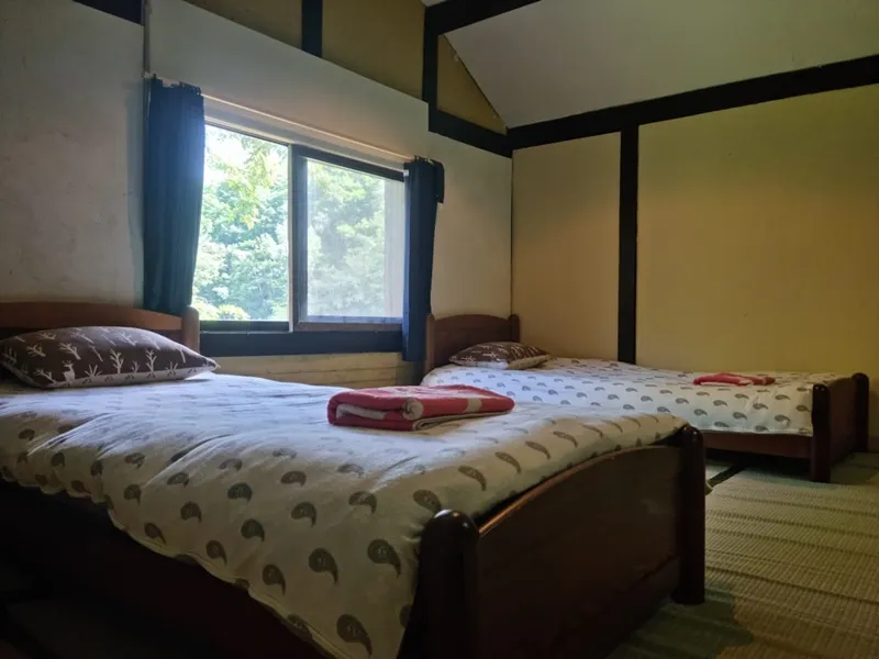 Tatami bedroom with two single beds beside a garden window