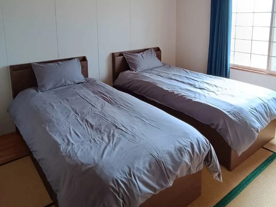 Tatami bedroom with twin beds and blue curtains