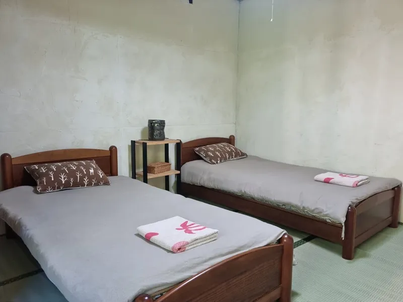 Twin bedroom with grey duvets and green tatami floor