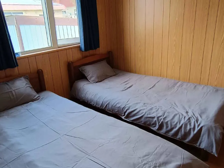 Twin bedroom with single beds and dark wood panelling
