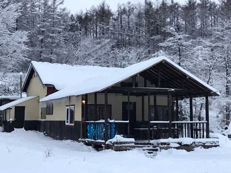 Bears House exterior in deep snow with sleds on the porch